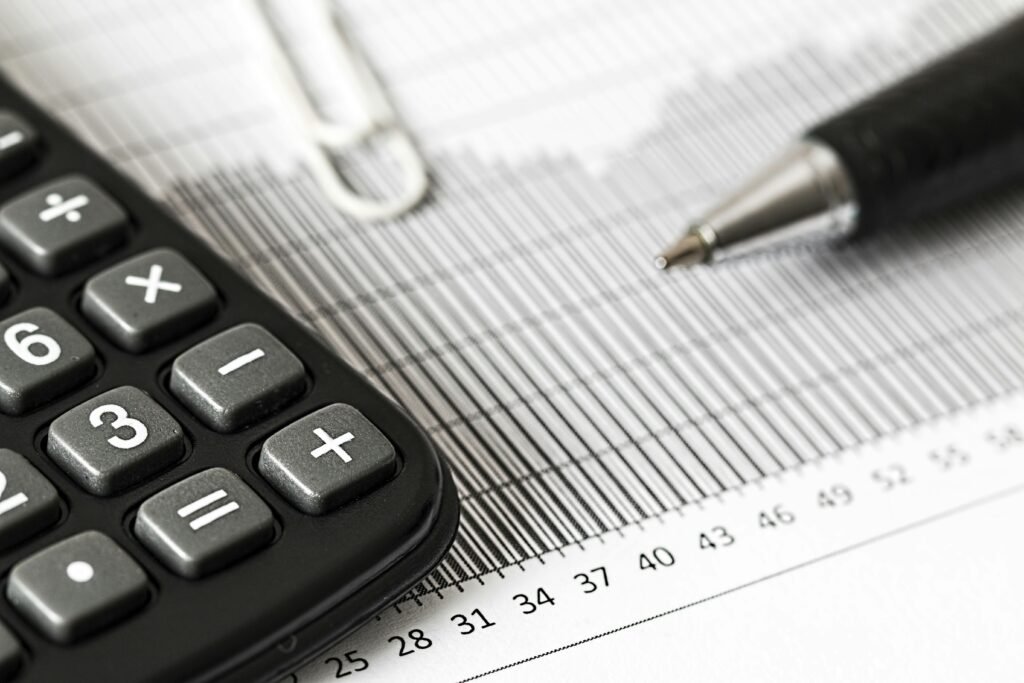 Required Documents for VAT Registration in UAE Close-up of a calculator and pen on a bar graph, representing finance and accounting.